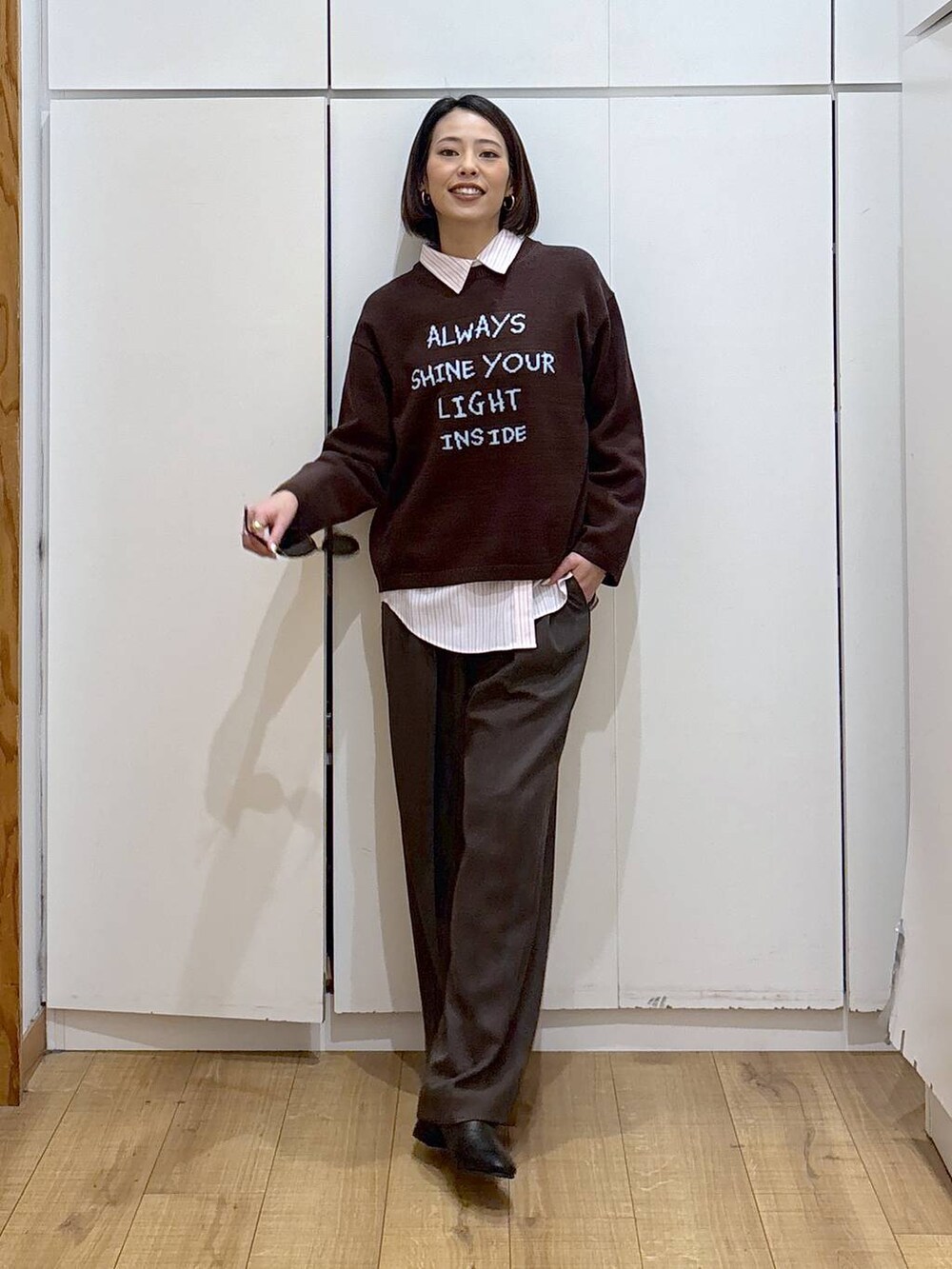 ピンク系のシャツ/ブラウス、ブラック系のブーツ、ブラウン系のニット/セーターを着用したレディースの冬コーディネートの4枚目の写真