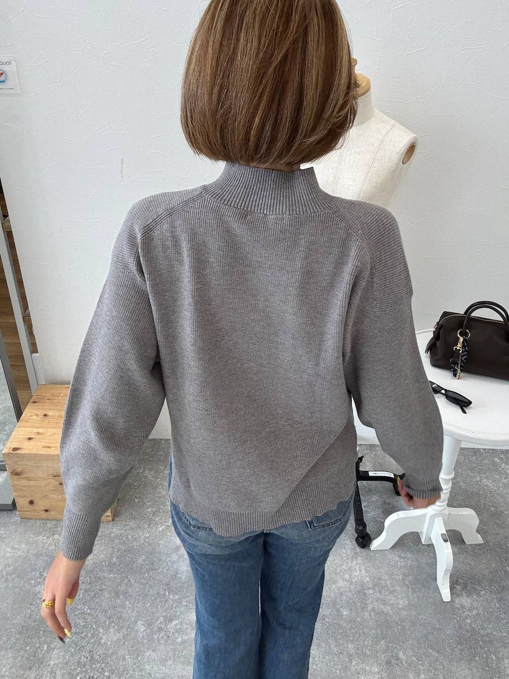 ブラック系のボストンバッグ、ブルー系のデニムパンツ、ブラック系のパンプスを着用したレディースの秋コーディネートの4枚目の写真