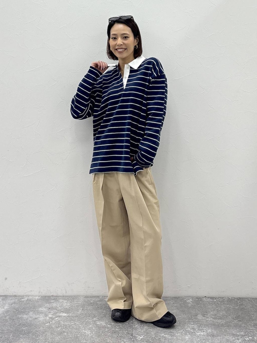 ブラック系のスニーカー、ベージュ系のチノパンツ、グリーン系のスウェットを着用したレディースの冬コーディネートの4枚目の写真