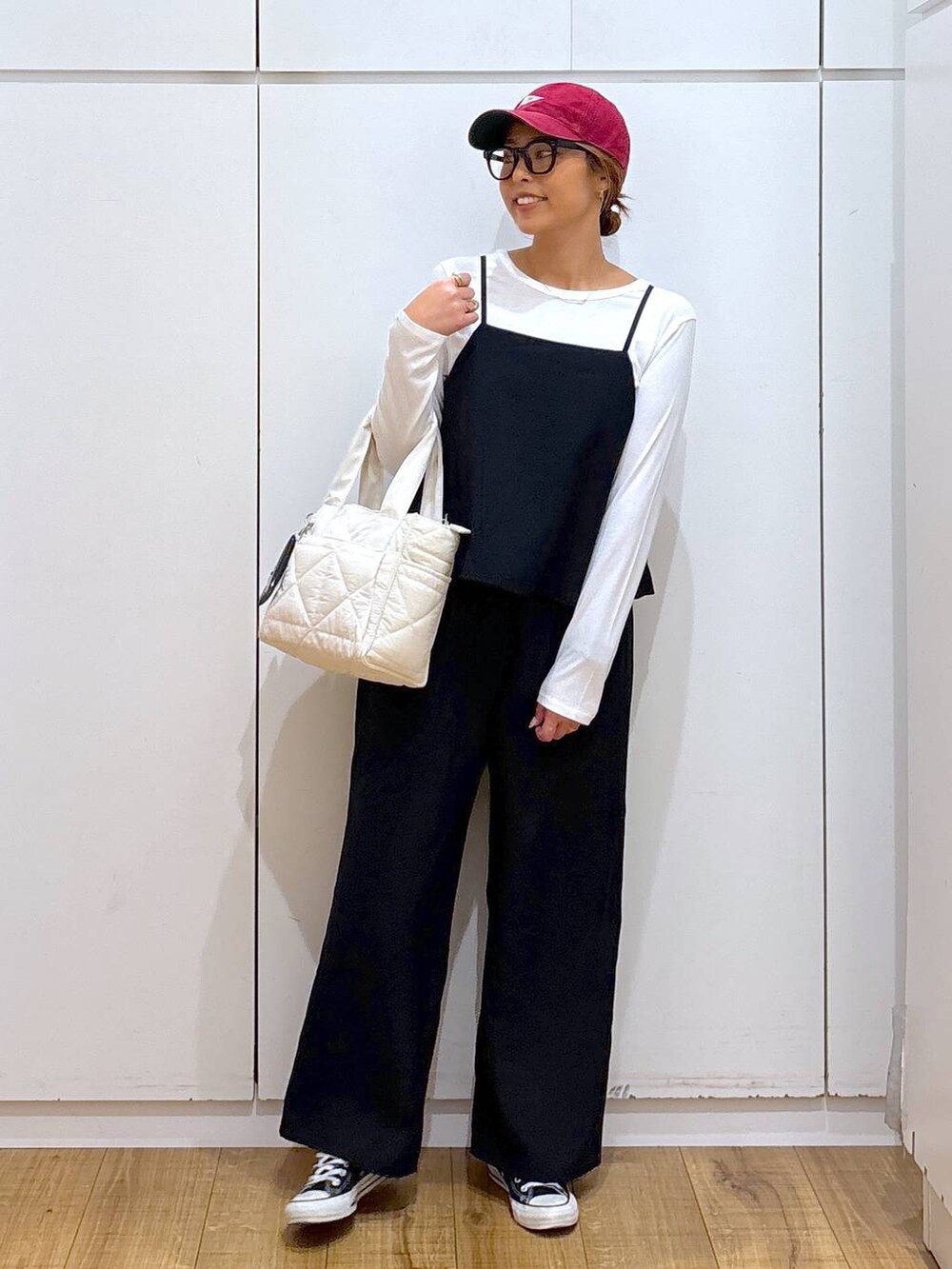 ホワイト系のトートバッグ、ブラック系のサロペット/オーバーオール、ブラック系のサングラスを着用したレディースの秋コーディネートの2枚目の写真