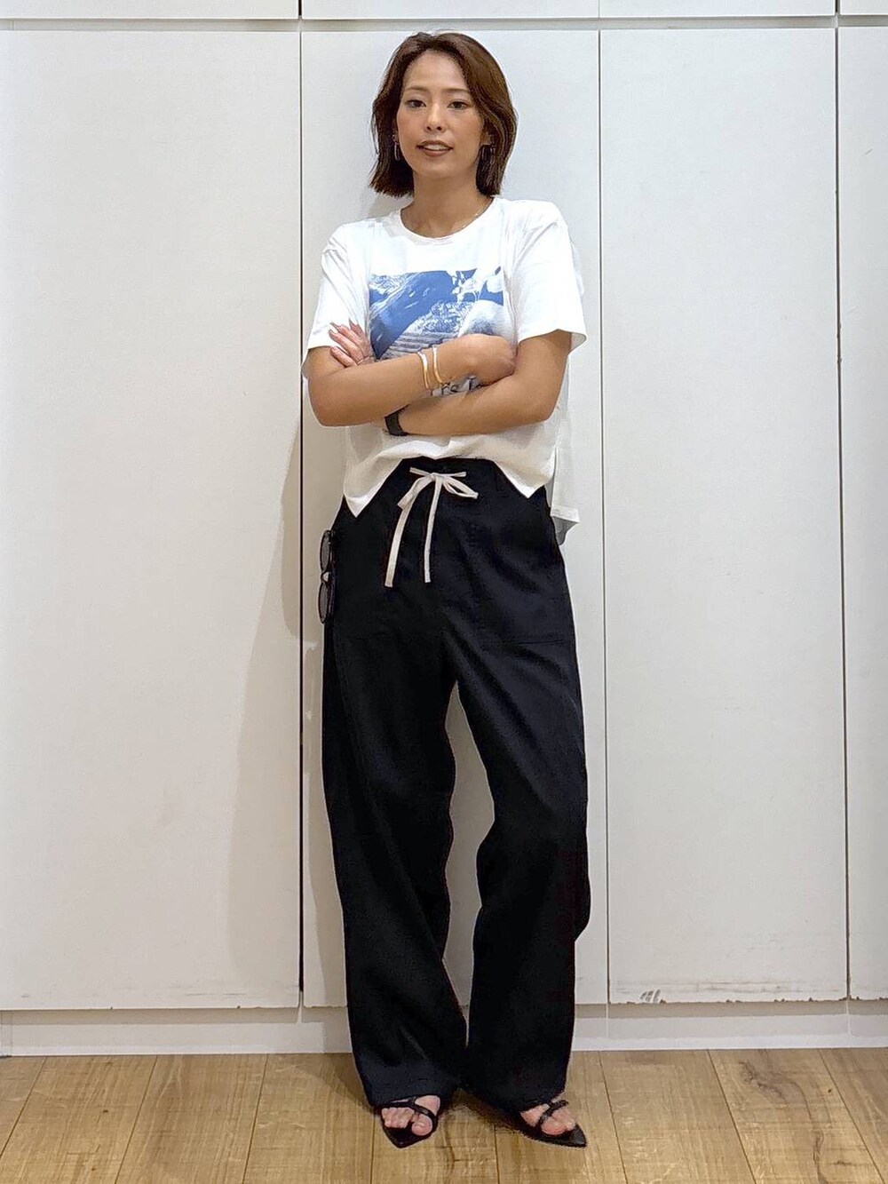 ホワイト系のTシャツ/カットソー、グリーン系のその他パンツ、ブラック系のサンダルを着用したレディースの夏コーディネートの2枚目の写真