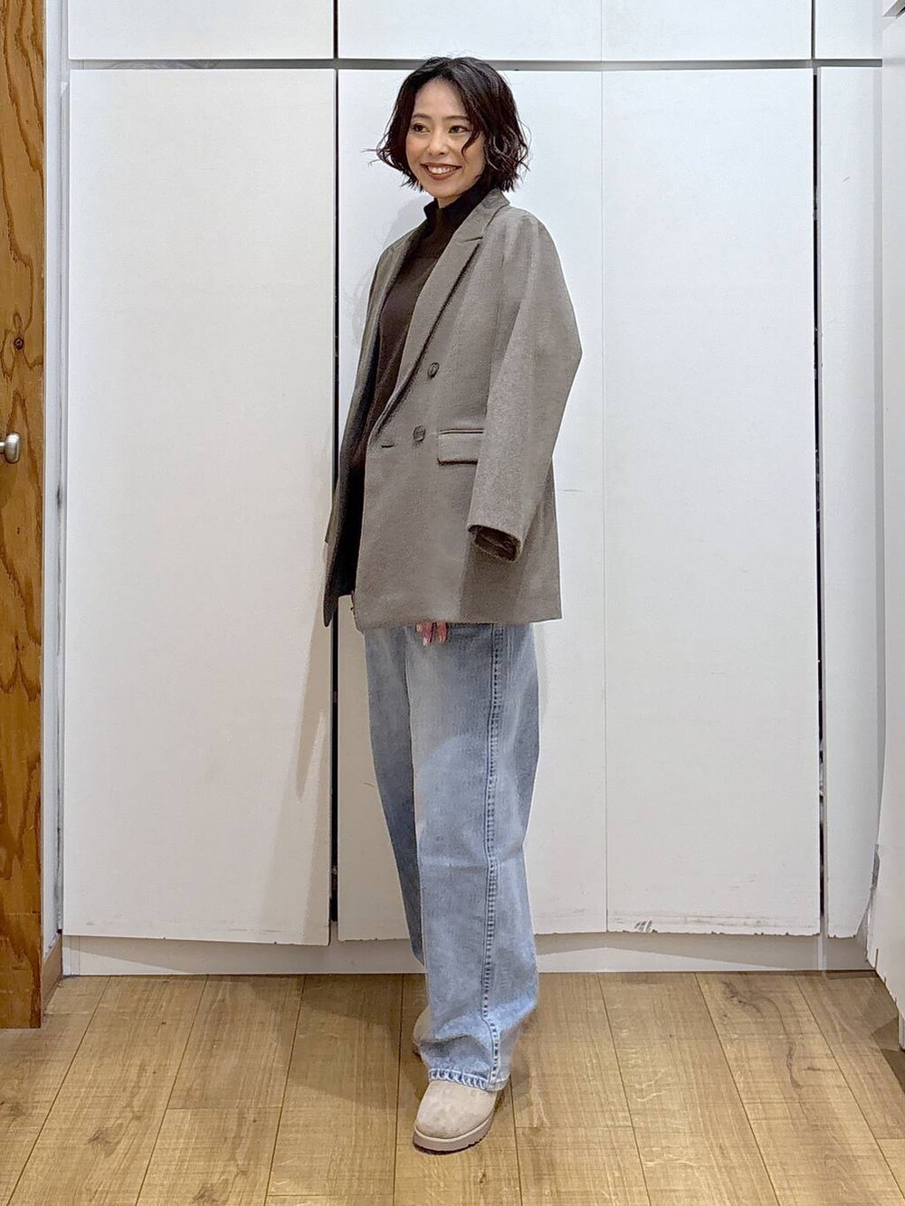 ブルー系のデニムパンツ、ブラウン系のニット/セーター、ブラウン系のテーラードジャケットを着用したレディースの冬コーディネートの4枚目の写真