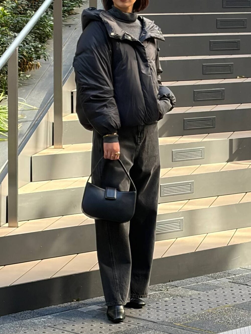 ブラック系のダウンジャケット/コート、ブラック系のデニムパンツ、ブラック系のブーツを着用したレディースの秋コーディネートの2枚目の写真