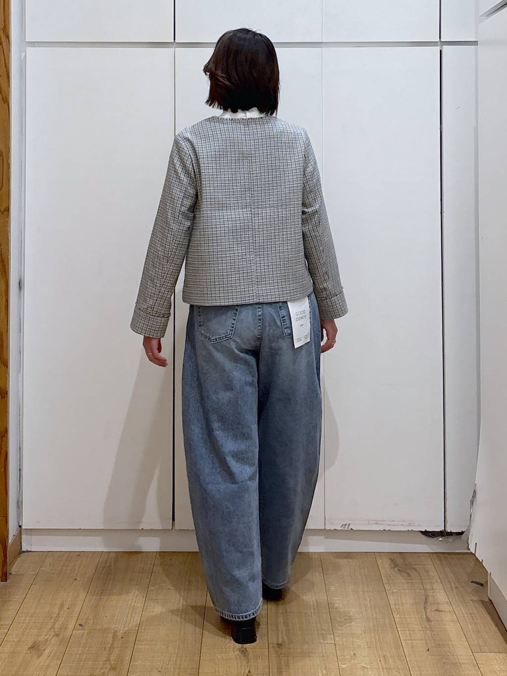 ブラック系のセットアップ、ホワイト系のテーラードジャケット、ブラック系のブーツを着用したレディースの冬コーディネートの5枚目の写真