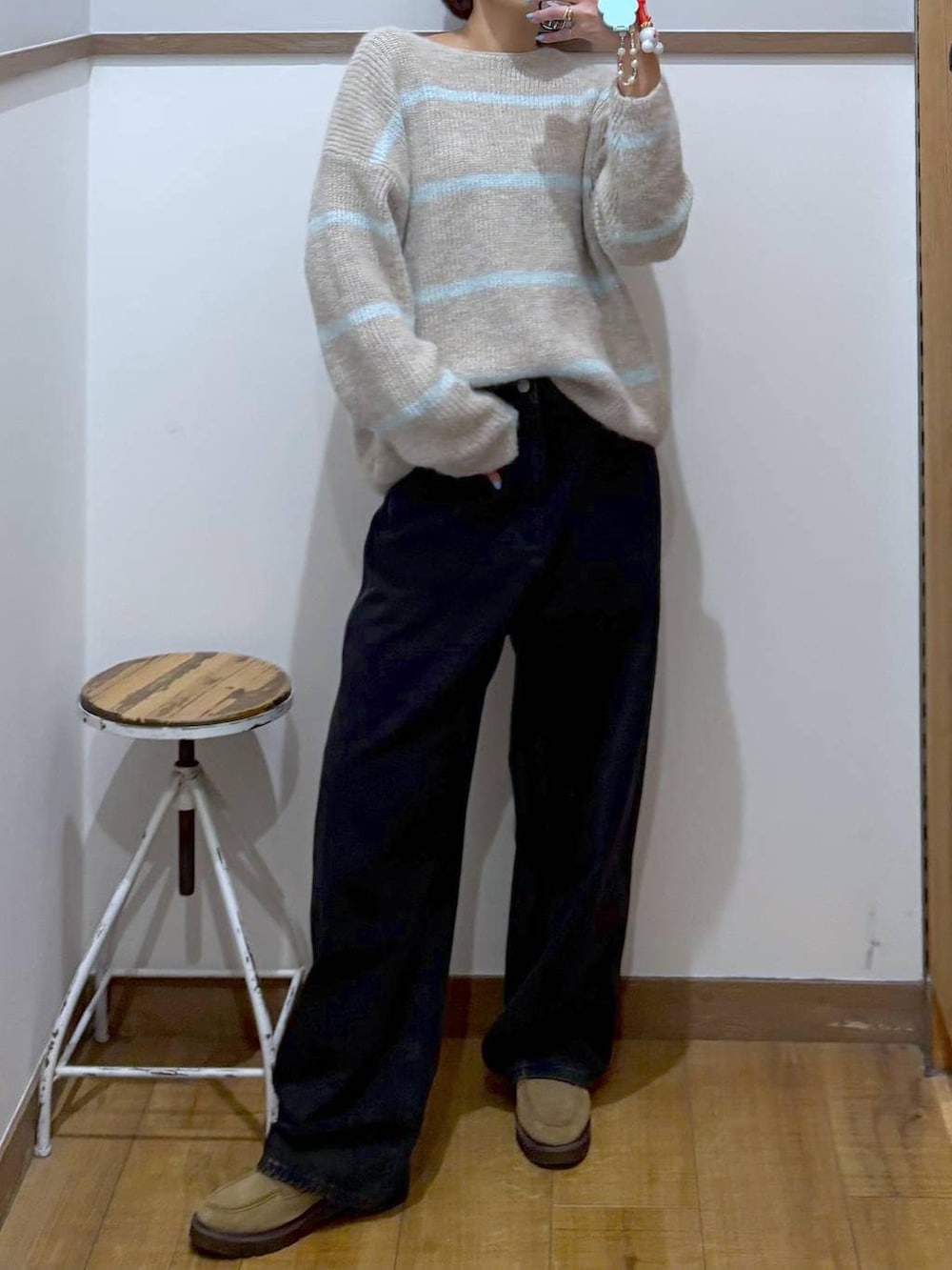 ブラック系のデニムパンツ、ベージュ系のローファー、ベージュ系のニット/セーターを着用したレディースの冬コーディネートの2枚目の写真