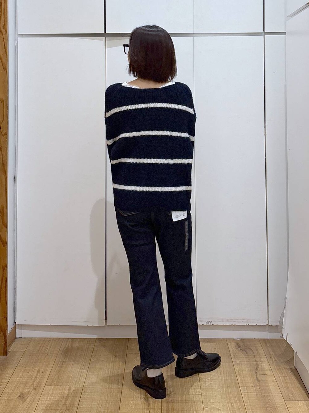 ベージュ系のダウンジャケット/コート、ブルー系のデニムパンツ、ブルー系のニット/セーターを着用したレディースの秋コーディネートの6枚目の写真