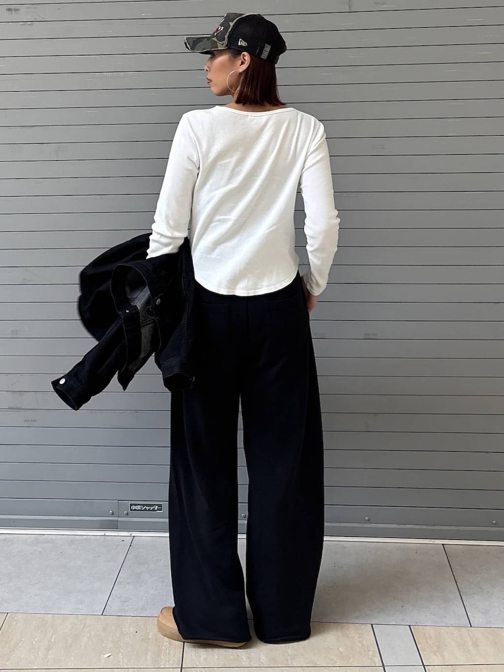 ブラック系のデニムジャケット、ブラック系のスウェットパンツ、ゴールド系のネックレスを着用したレディースの春コーディネートの8枚目の写真