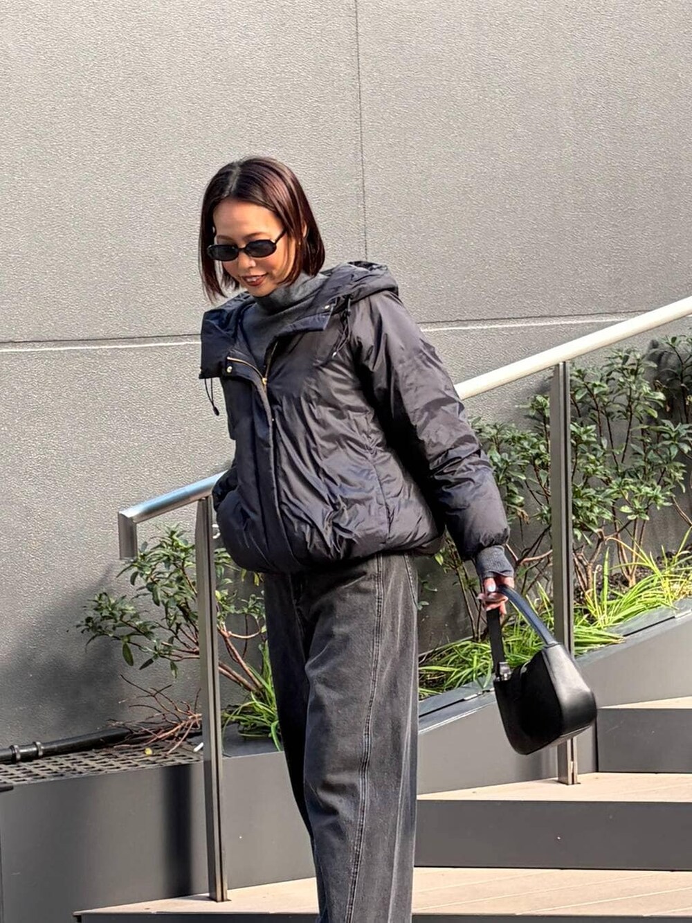 ブラック系のダウンジャケット/コート、ブラック系のデニムパンツ、ブラック系のブーツを着用したレディースの秋コーディネートの5枚目の写真