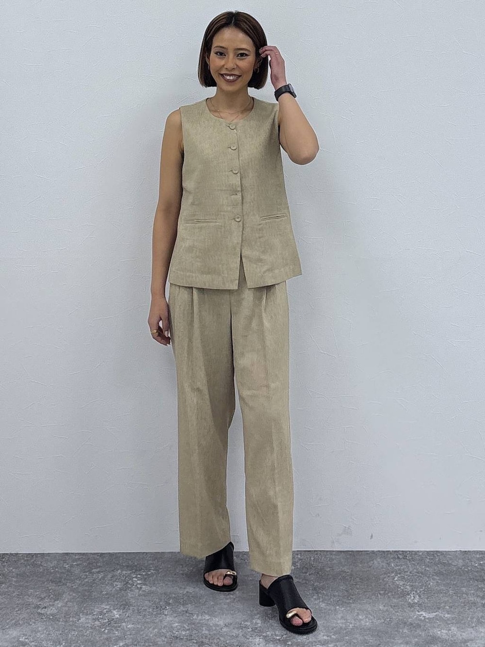 ベージュ系のその他パンツ、ベージュ系のベスト、ゴールド系のネックレスを着用したレディースの春コーディネートの6枚目の写真