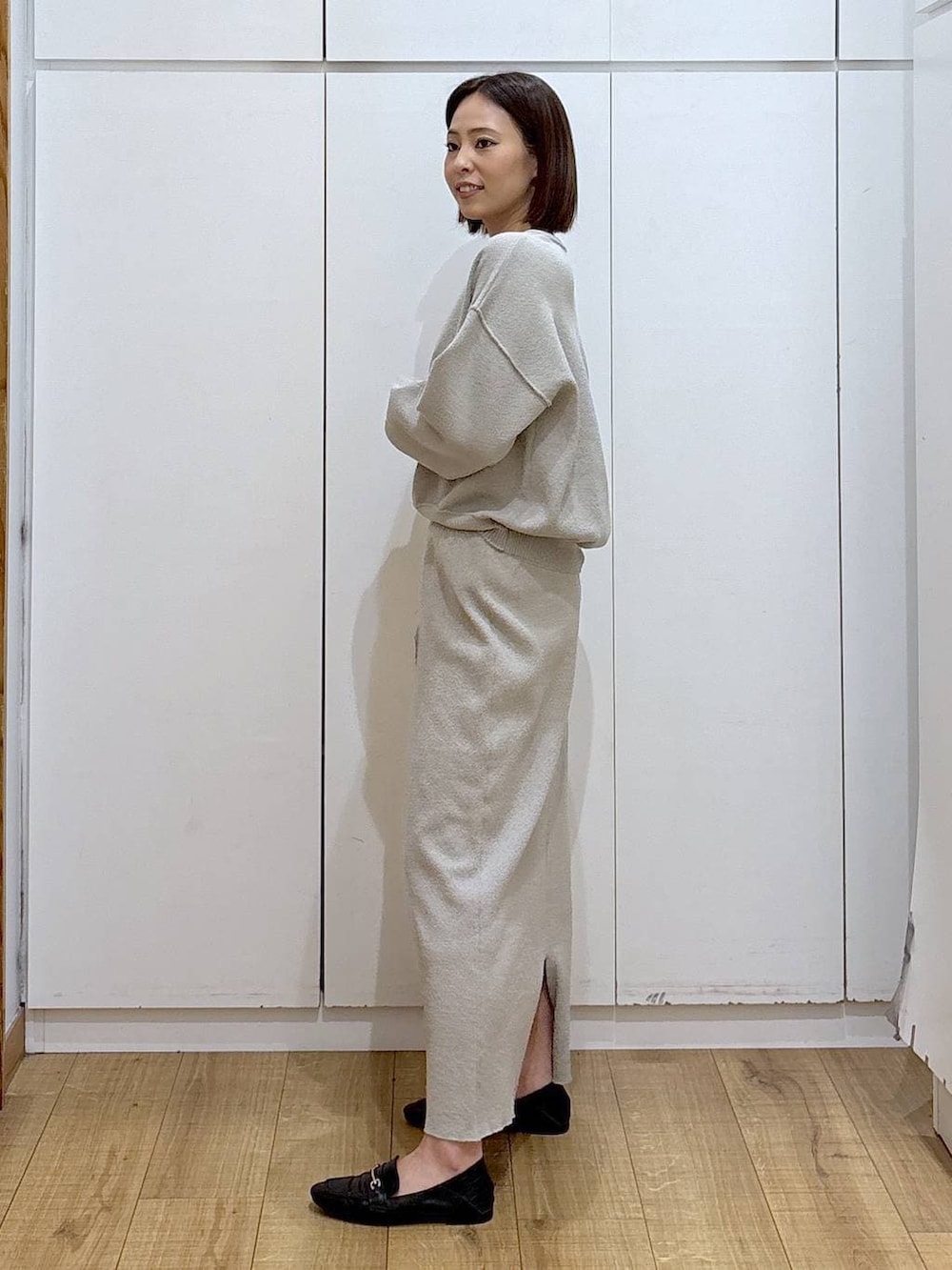 ブラック系のローファー、ベージュ系のワンピース、ゴールド系のピアス(両耳用)を着用したレディースの冬コーディネートの3枚目の写真