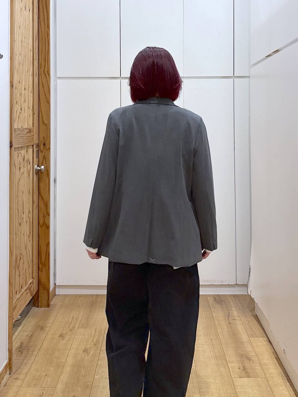 グレー系のテーラードジャケット、ブラック系のブーツ、ブラック系のデニムパンツを着用したレディースの春コーディネートの9枚目の写真