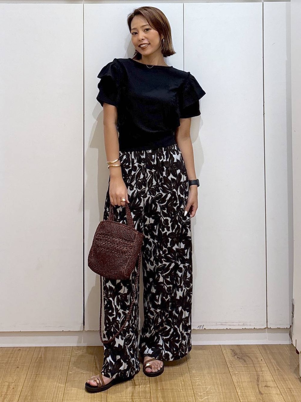 ベージュ系のその他パンツ、ブラウン系のクラッチバッグ、ブラック系のTシャツ/カットソーを着用したレディースの夏コーディネートの7枚目の写真