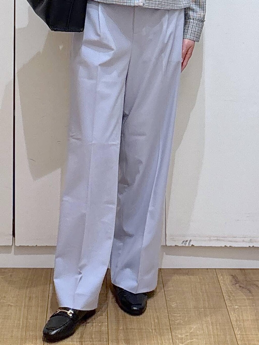 ブラック系のローファー、ブルー系のスラックス、ホワイト系のテーラードジャケットを着用したレディースの冬コーディネートの3枚目の写真