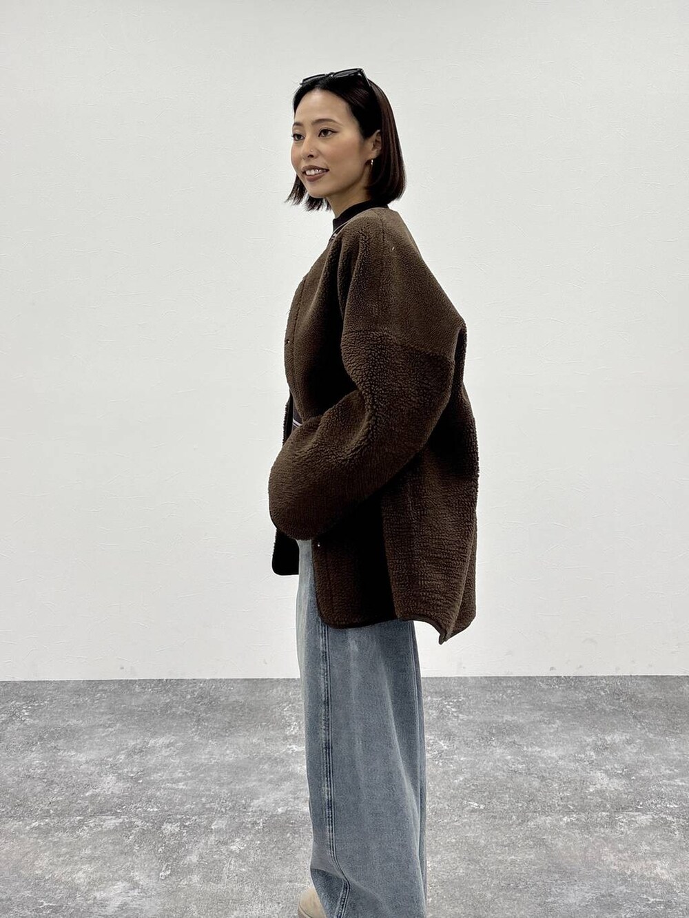 ホワイト系のニット/セーター、ブルー系のデニムパンツ、ブラウン系のノーカラージャケットを着用したレディースの冬コーディネートの9枚目の写真