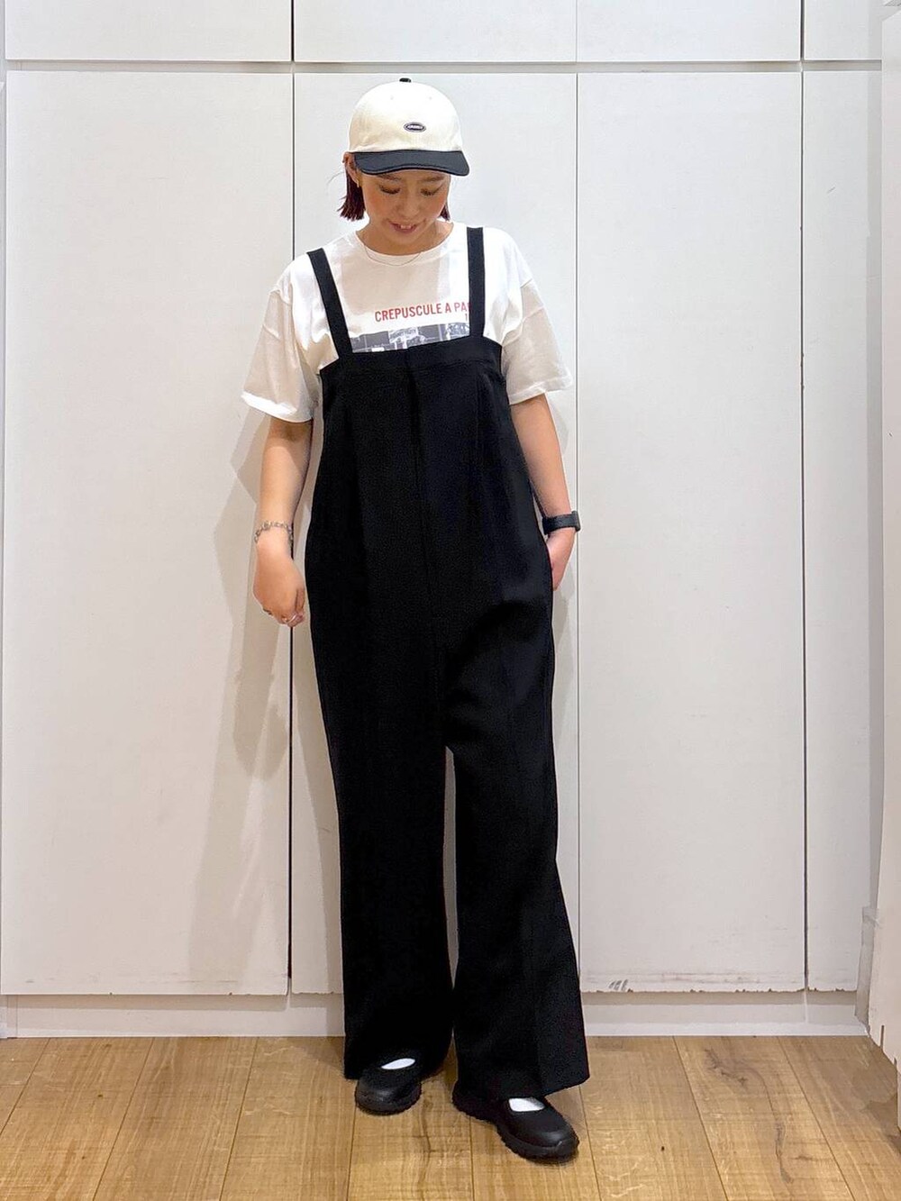 ブラック系のスニーカー、ホワイト系のTシャツ/カットソー、ブラック系のつなぎ/オールインワンを着用したレディースの春コーディネートの3枚目の写真