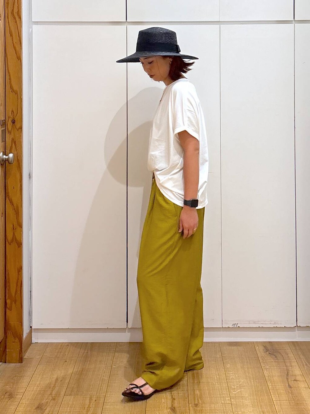 ブラック系のサンダル、イエロー系のその他パンツ、ホワイト系のTシャツ/カットソーを着用したレディースの夏コーディネートの3枚目の写真