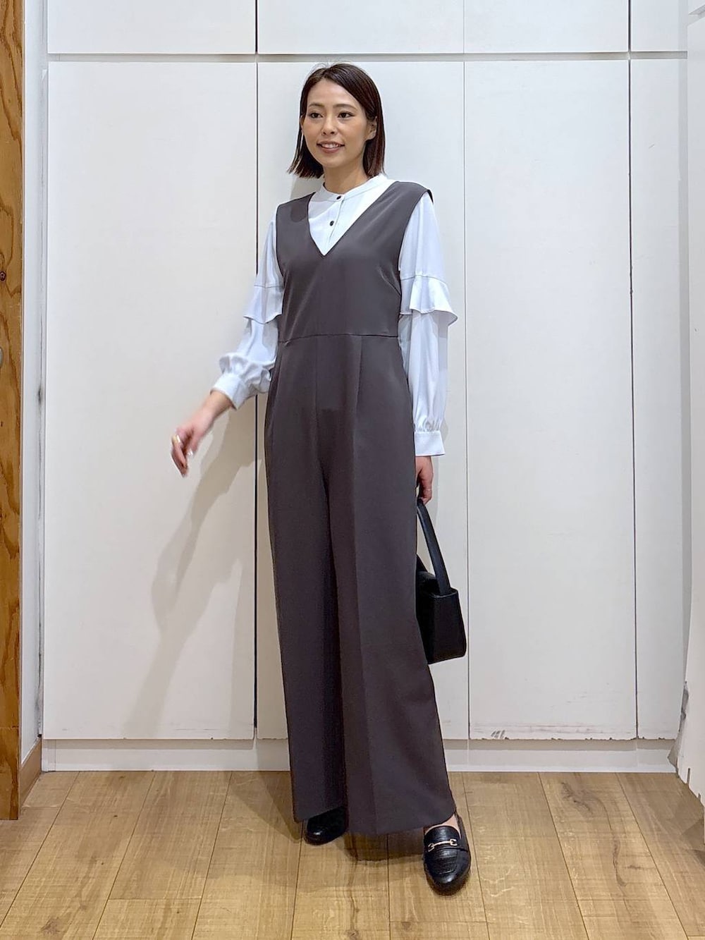 ブラック系のローファー、グレー系のセットアップ、ブラック系のハンドバッグを着用したレディースの冬コーディネートの9枚目の写真