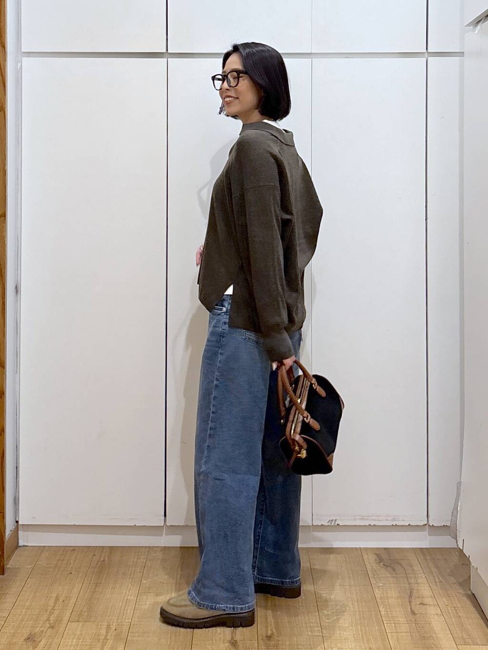 ホワイト系のニット/セーター、ベージュ系のローファー、ブルー系のデニムパンツを着用したレディースの秋コーディネートの5枚目の写真