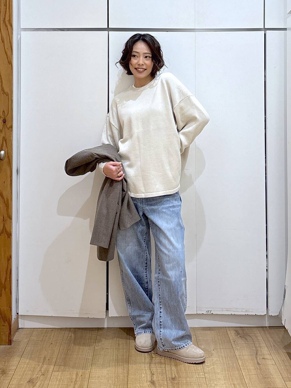 ブラック系のニット/セーター、ブルー系のデニムパンツ、ホワイト系のTシャツ/カットソーを着用したレディースの冬コーディネートの3枚目の写真