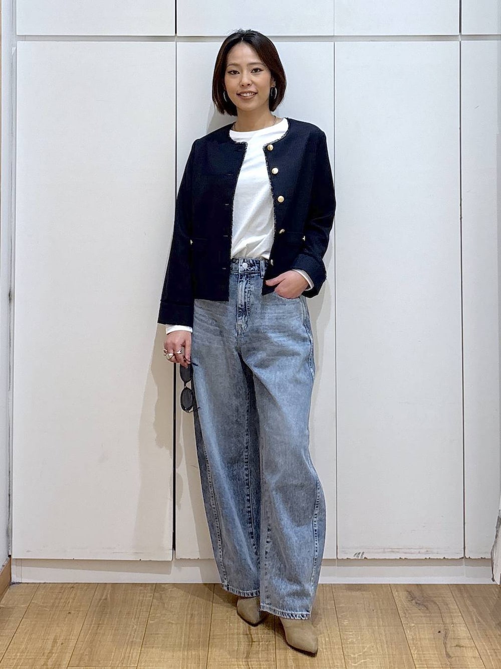 ホワイト系のTシャツ/カットソー、ブルー系のテーラードジャケット、ベージュ系のブーツを着用したレディースの冬コーディネートの6枚目の写真