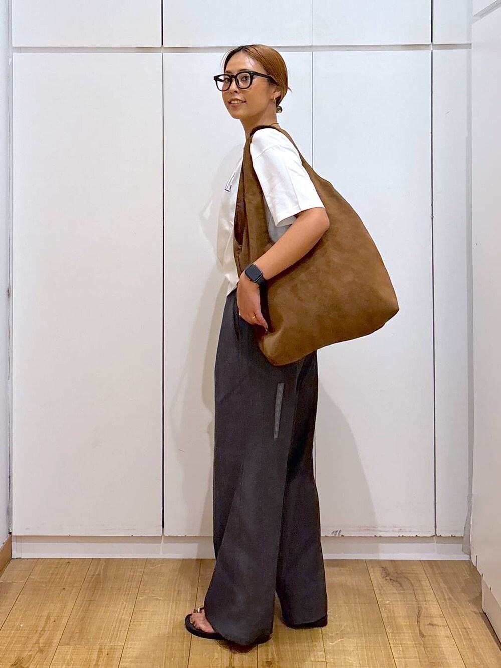 ホワイト系のTシャツ/カットソー、ブラウン系のサンダル、グレー系のその他パンツを着用したレディースの秋コーディネートの2枚目の写真