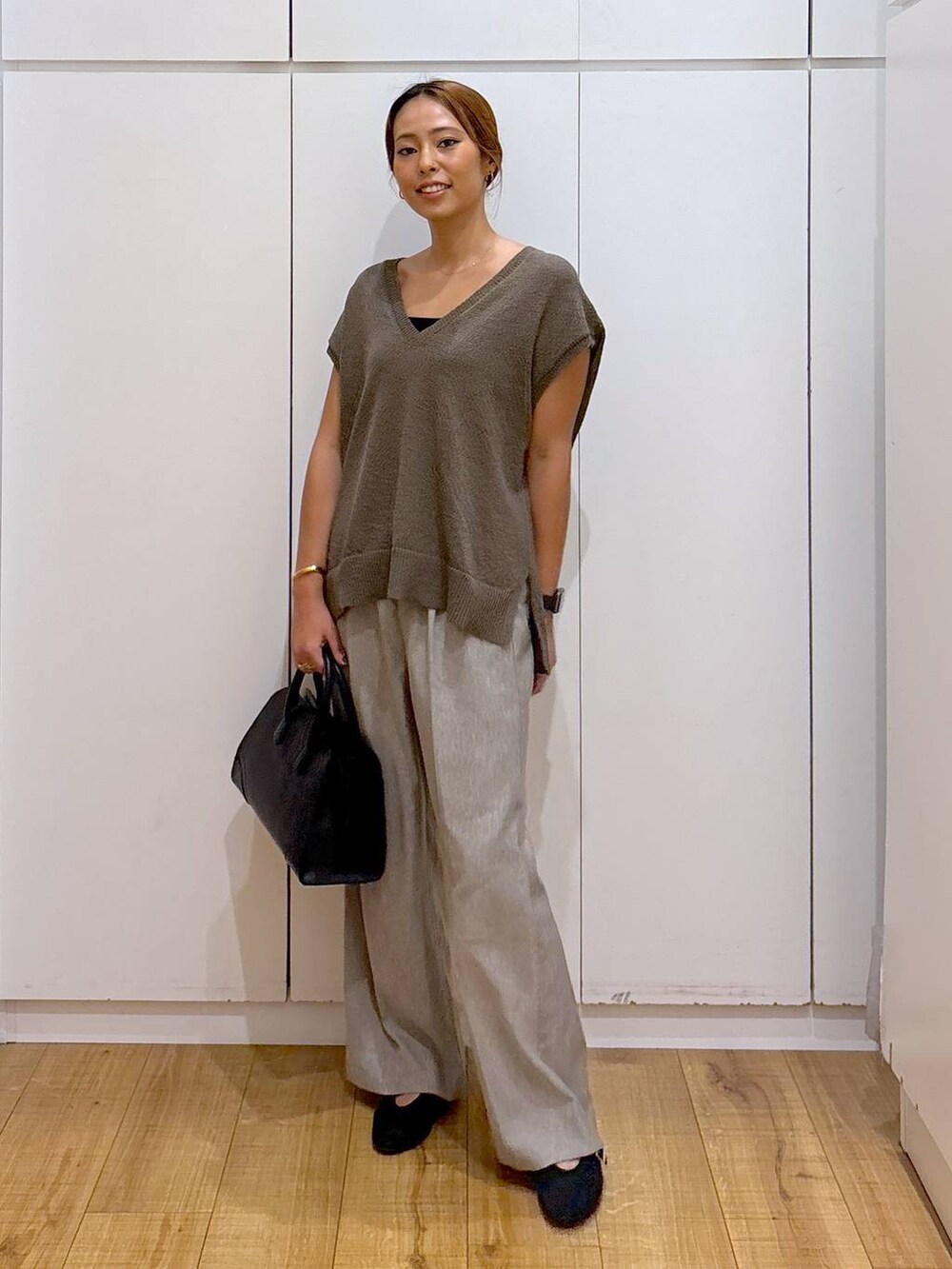 ブラック系のキャミソール、ブラウン系のベスト、ベージュ系のその他パンツを着用したレディースの秋コーディネートの2枚目の写真