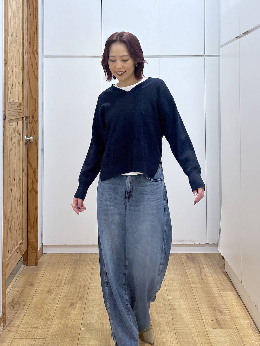 ブルー系のデニムパンツ、ブルー系のニット/セーター、ゴールド系のリングを着用したレディースの春コーディネートの6枚目の写真