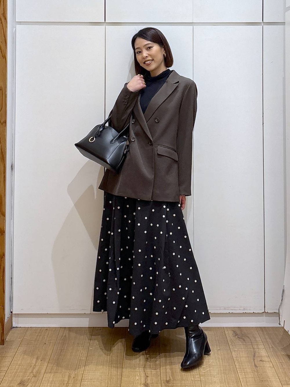 ブラック系のショルダーバッグ、ブラック系のTシャツ/カットソー、ブラック系のブーツを着用したレディースの冬コーディネートの3枚目の写真