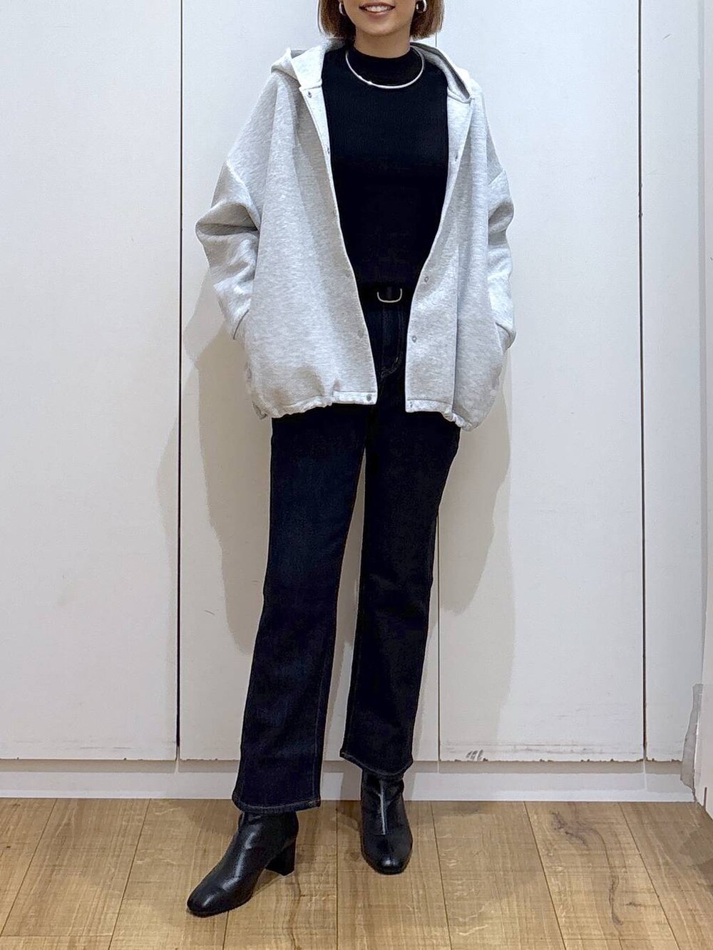 ブルー系のデニムパンツ、ブラック系のニット/セーター、グレー系のブルゾンを着用したレディースの秋コーディネートの4枚目の写真