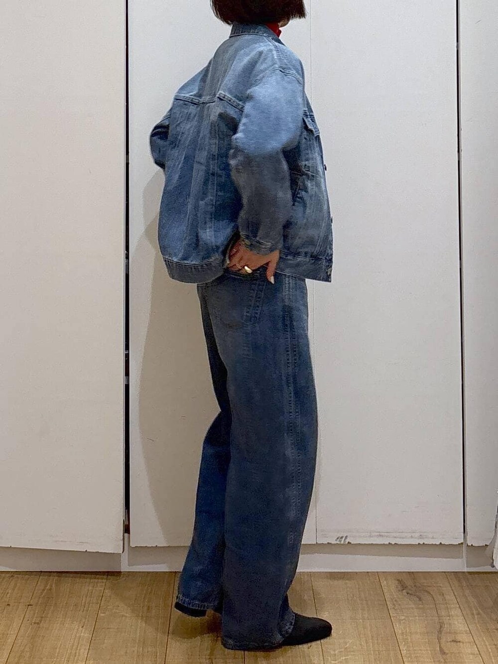 レッド系のニット/セーター、ブラック系のブーツ、ブルー系のデニムジャケットを着用したレディースの冬コーディネートの5枚目の写真