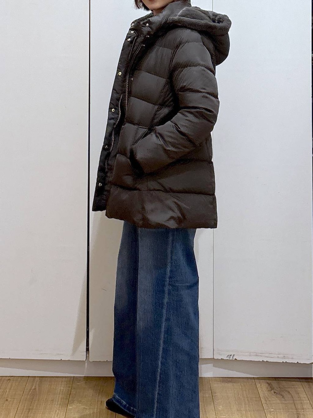 ブラック系のニット/セーター、ブラウン系のダウンジャケット/コート、ホワイト系のTシャツ/カットソーを着用したレディースの冬コーディネートの4枚目の写真