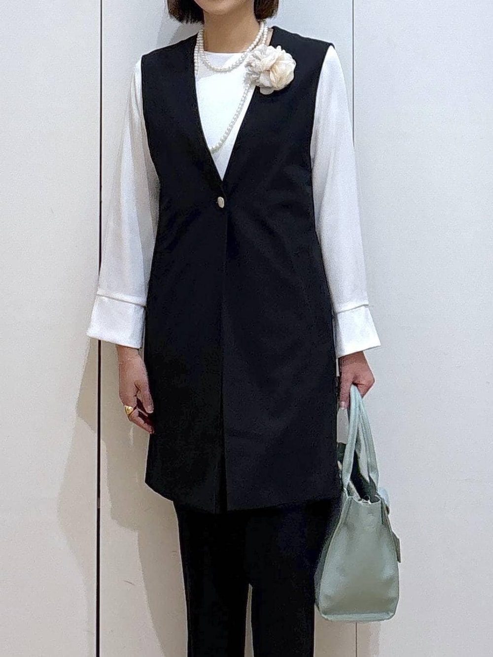 ブラック系のパンプス、ブラック系のスラックス、ブラック系のセットアップを着用したレディースの冬コーディネートの5枚目の写真