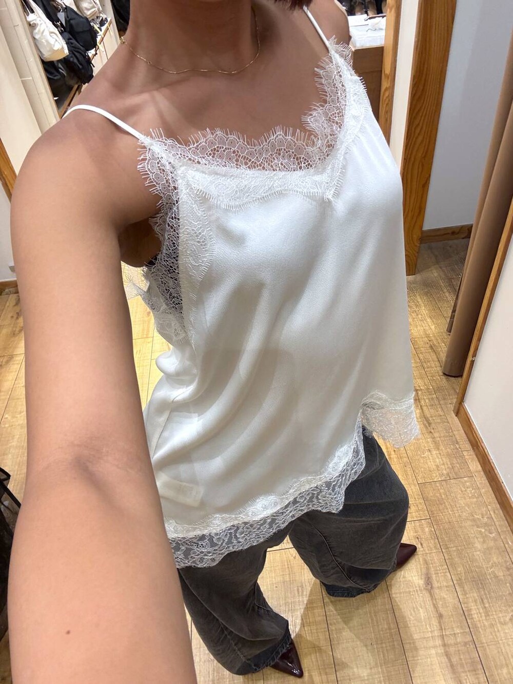 ブラック系のデニムパンツ、ホワイト系のキャミソールを着用したレディースの夏コーディネートの5枚目の写真