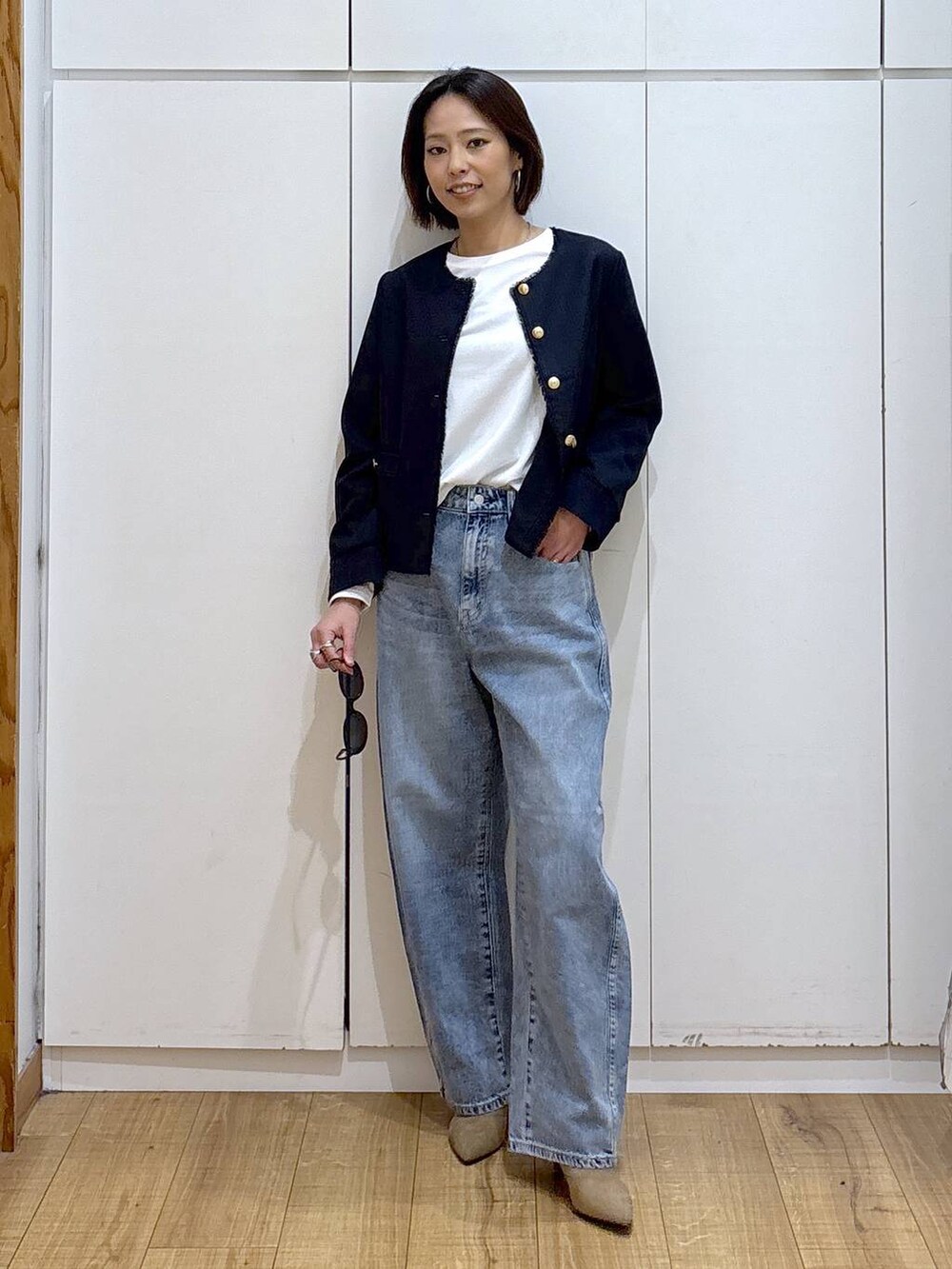 ホワイト系のTシャツ/カットソー、ブルー系のテーラードジャケット、ベージュ系のブーツを着用したレディースの冬コーディネートの2枚目の写真