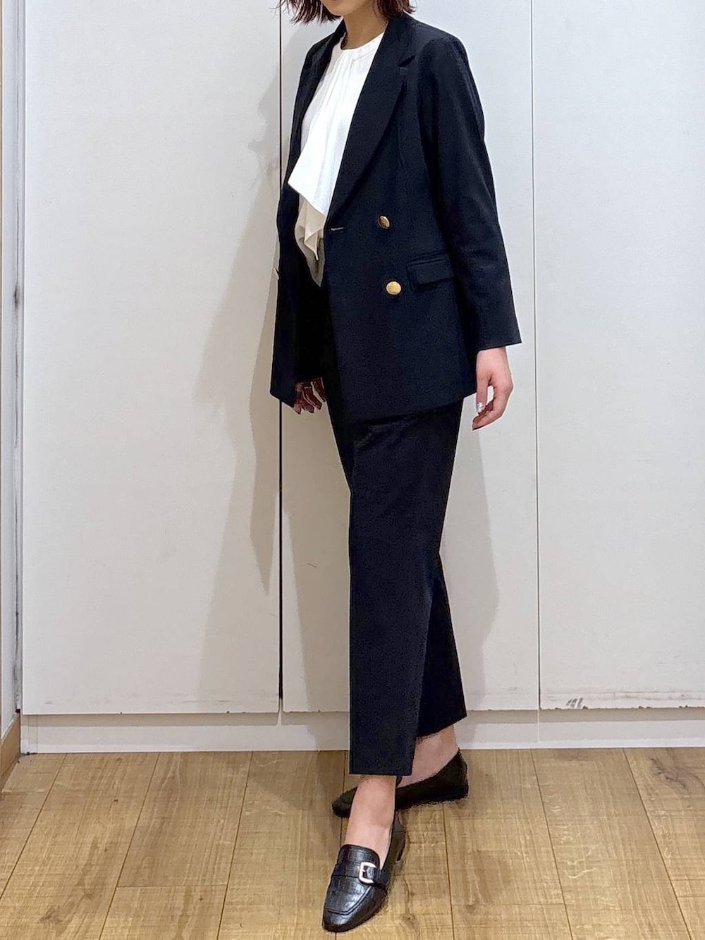 ブラック系のローファー、ブルー系のスラックス、ホワイト系のシャツ/ブラウスを着用したレディースの春コーディネートの6枚目の写真