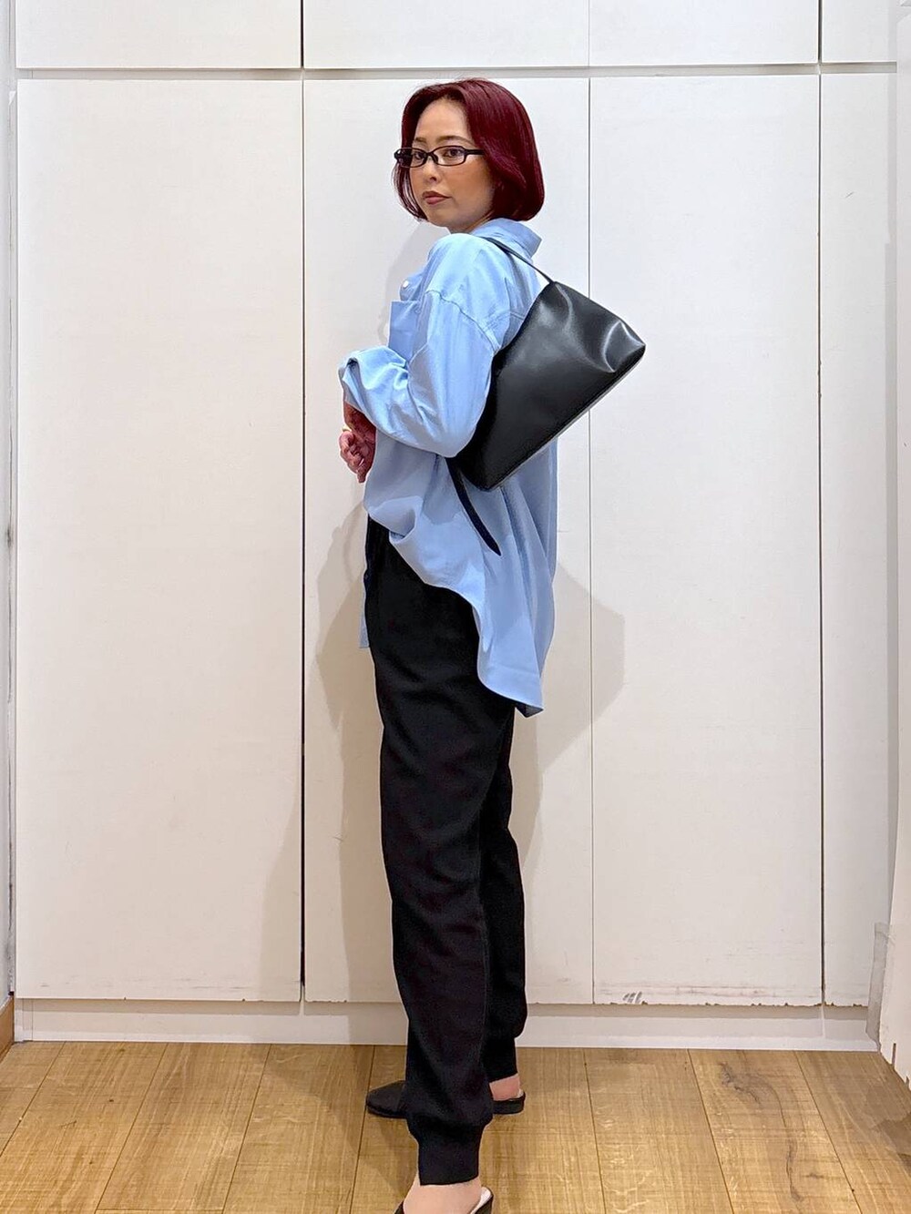 ブラック系のショルダーバッグ、ブラック系のその他パンツ、ブルー系のシャツ/ブラウスを着用したレディースの春コーディネートの2枚目の写真