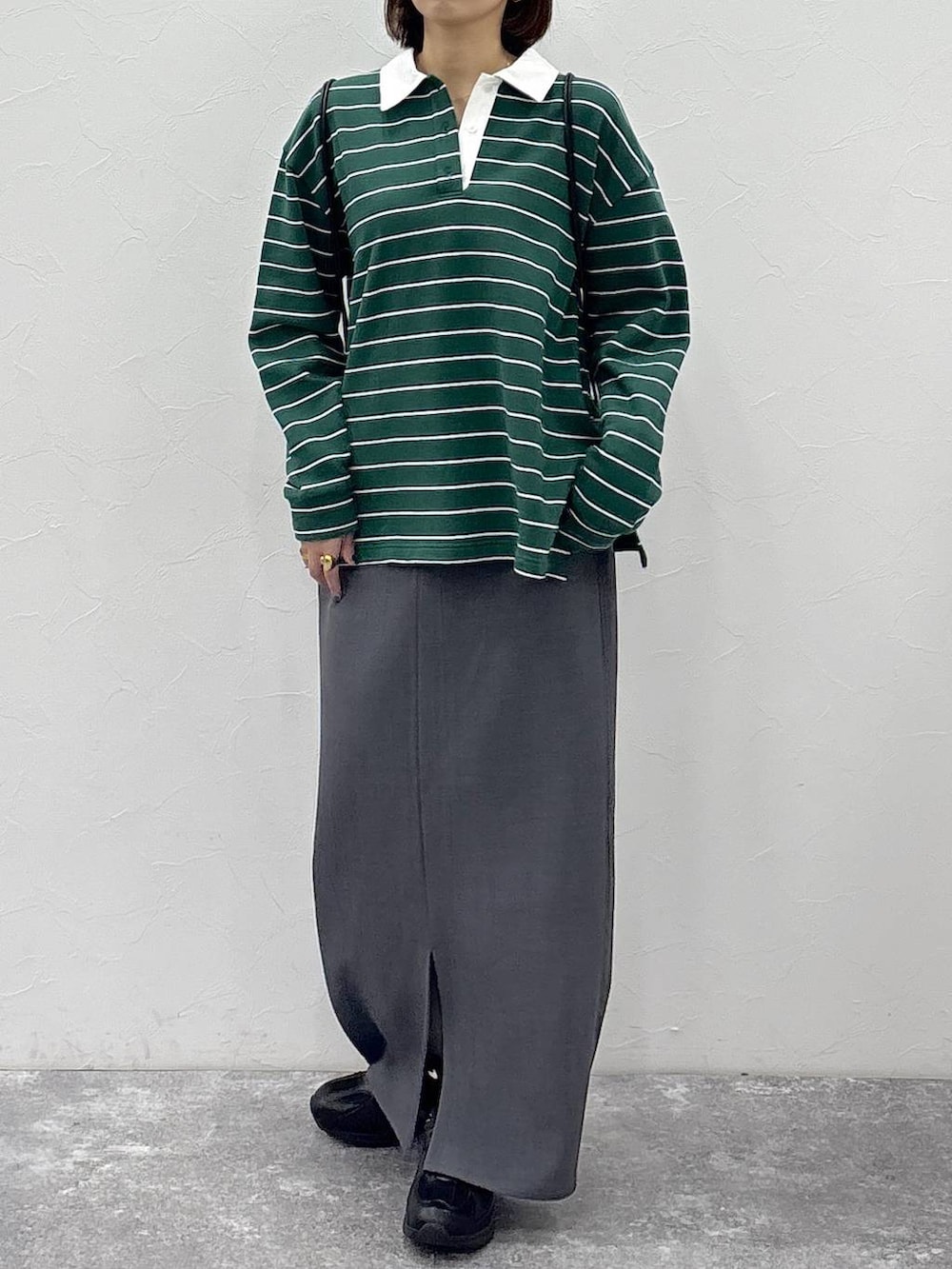 ブラック系のスニーカー、ベージュ系のスカート、グリーン系のスウェットを着用したレディースの冬コーディネートの2枚目の写真