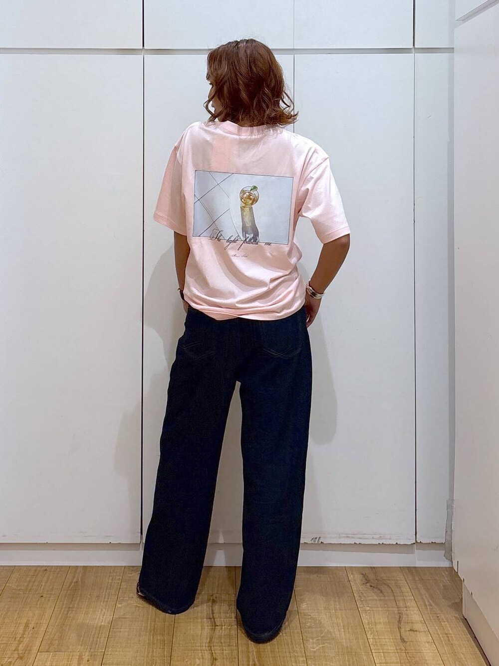 ブルー系のデニムパンツ、ピンク系のTシャツ/カットソー、ブラック系のサンダルを着用したレディースの夏コーディネートの3枚目の写真