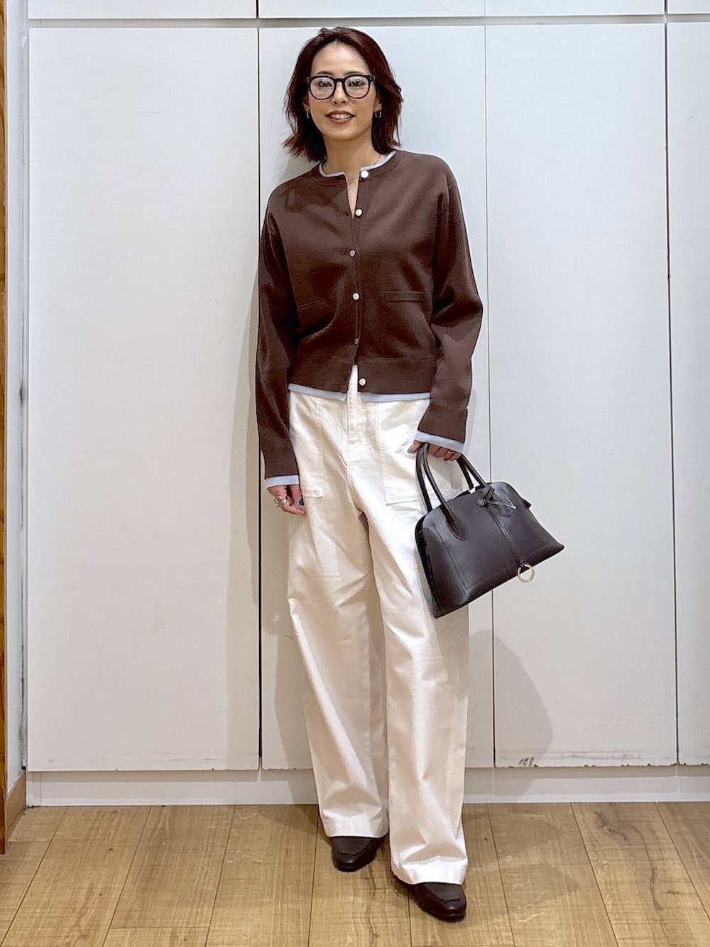 ブラウン系のローファー、ブラウン系のショルダーバッグ、ブラウン系のカーディガン/ボレロを着用したレディースの春コーディネートの2枚目の写真