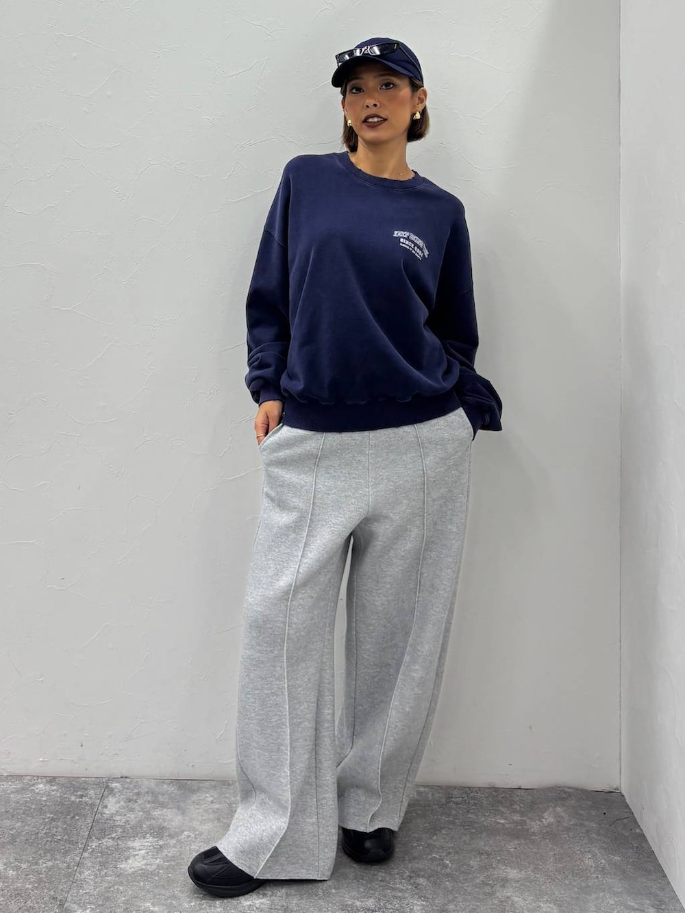 ブラック系のスニーカー、グレー系のその他パンツ、ブルー系のキャップを着用したレディースの秋コーディネートの3枚目の写真