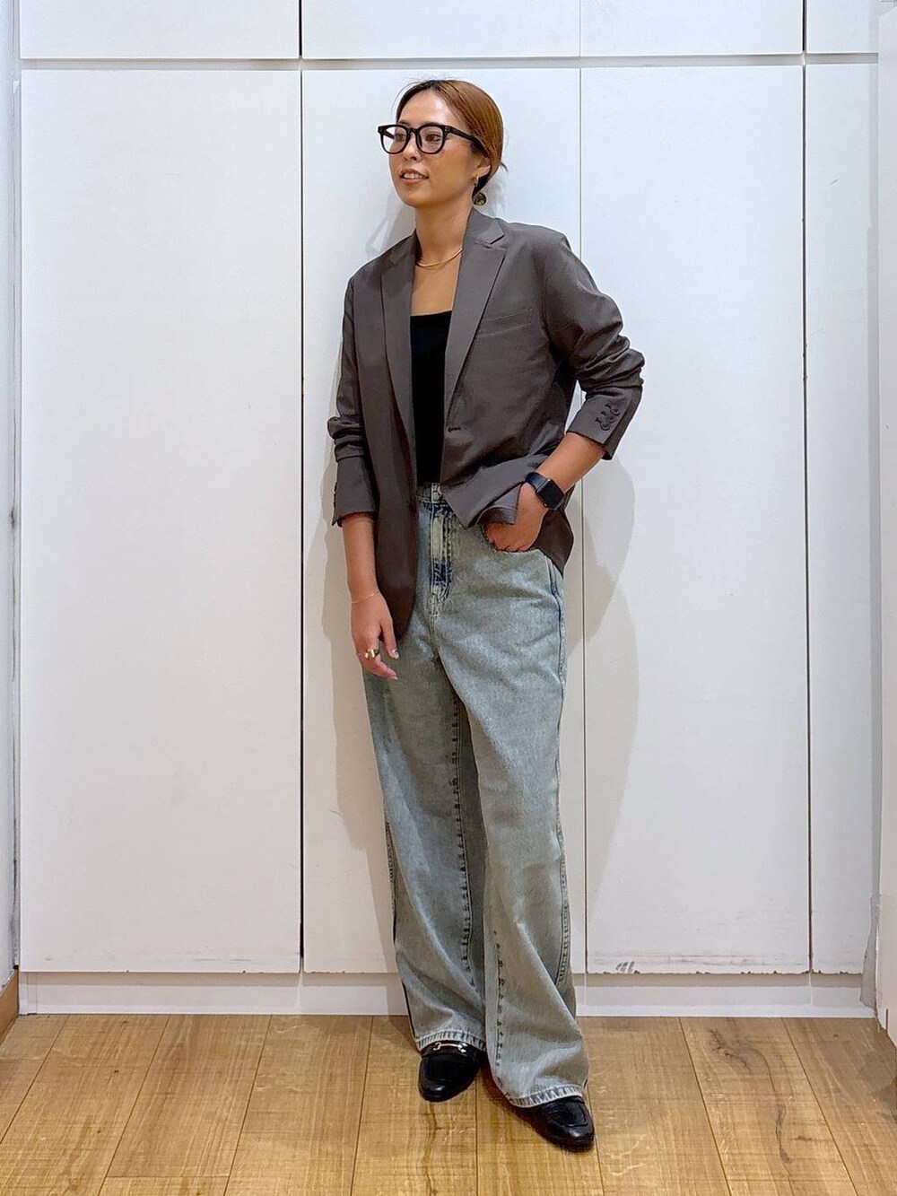 ブラック系のローファー、ブラック系のキャミソール、ブルー系のデニムパンツを着用したレディースの秋コーディネートの2枚目の写真