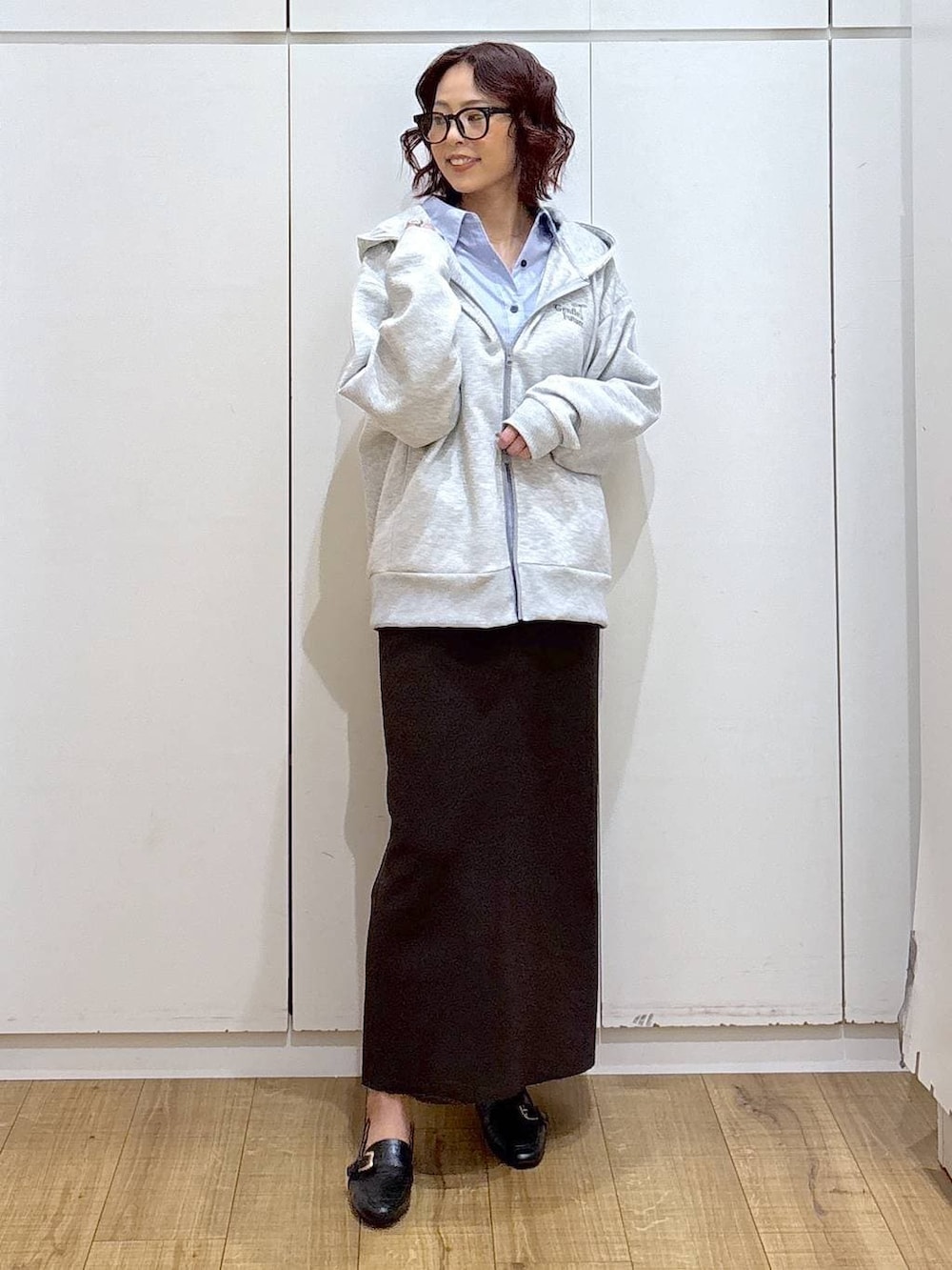 ブラック系のローファー、ブルー系のシャツ/ブラウス、ブラウン系のワンピースを着用したレディースの春コーディネートの2枚目の写真