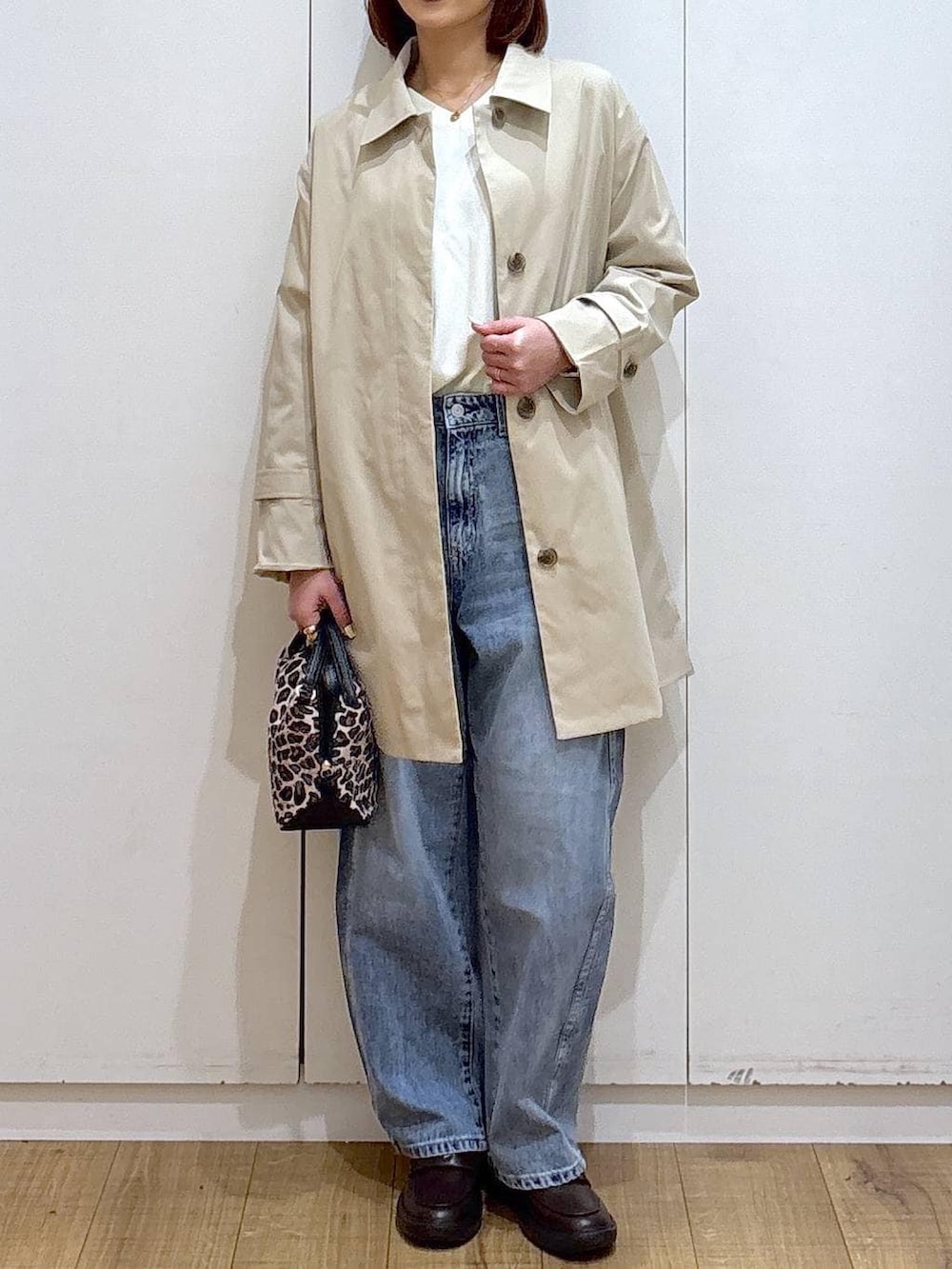 その他のショルダーバッグ、ブルー系のデニムパンツ、ベージュ系のステンカラーコートを着用したレディースの春コーディネートの2枚目の写真