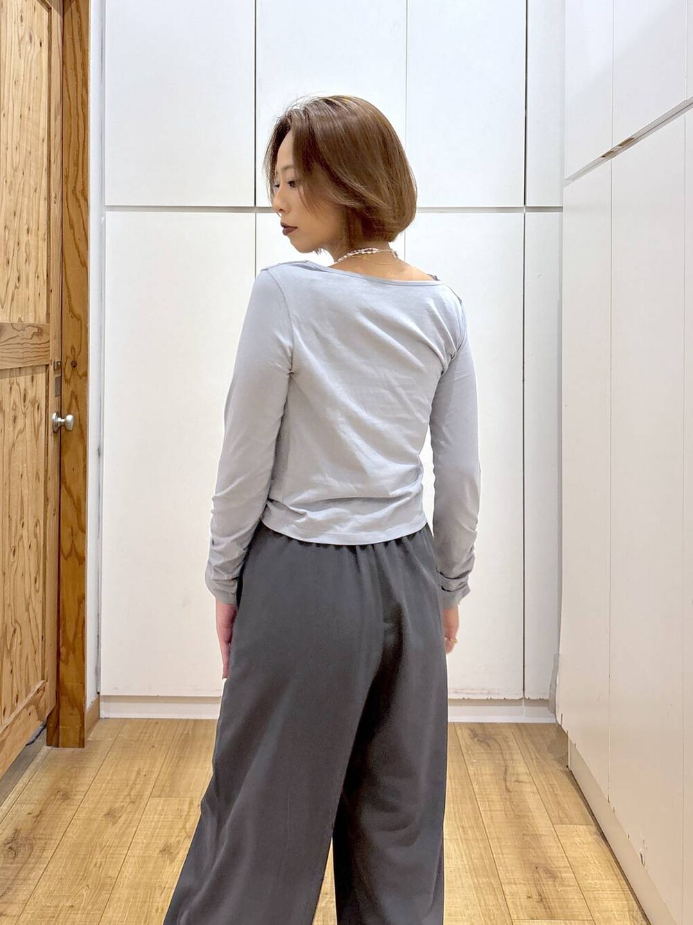 シルバー系のパンプス、グレー系のTシャツ/カットソー、グレー系のスラックスを着用したレディースの秋コーディネートの5枚目の写真