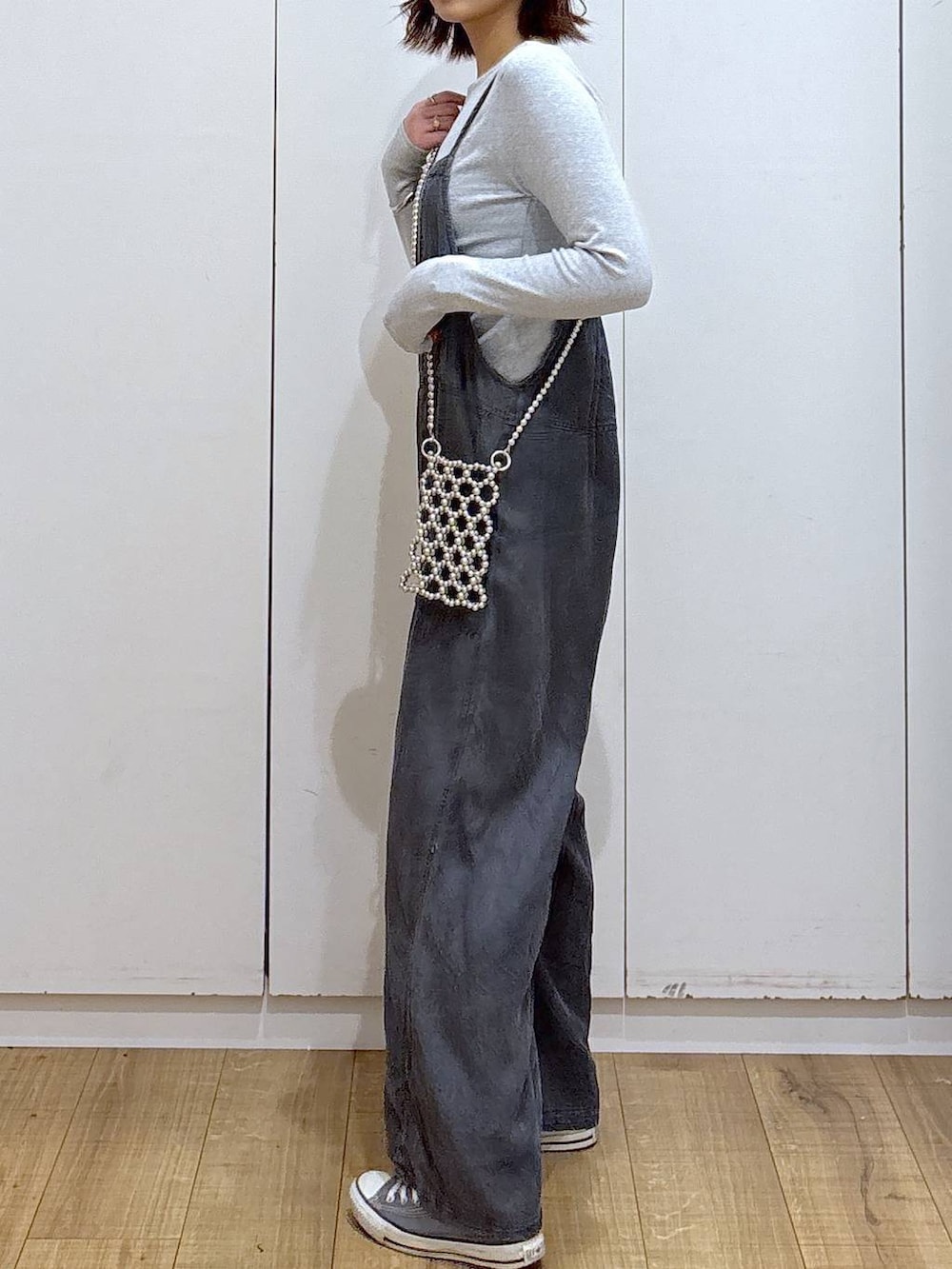 ブラック系のサロペット/オーバーオール、グレー系のスマホグッズを着用したレディースの春コーディネートの3枚目の写真