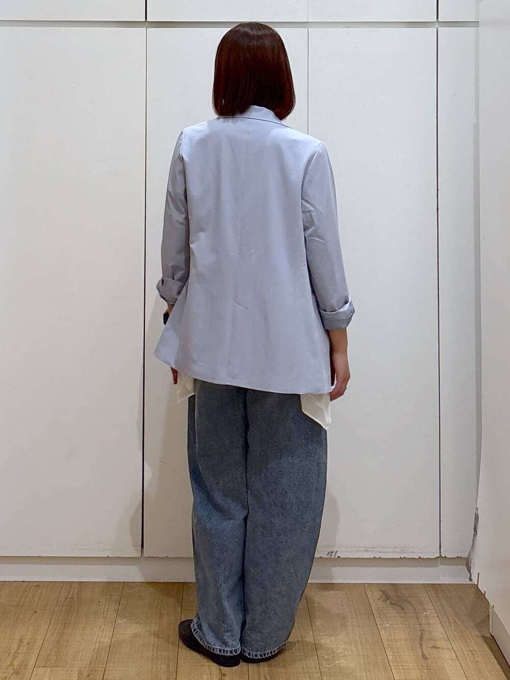 ブラック系のローファー、ブルー系のテーラードジャケット、ブルー系のデニムパンツを着用したレディースの春コーディネートの6枚目の写真