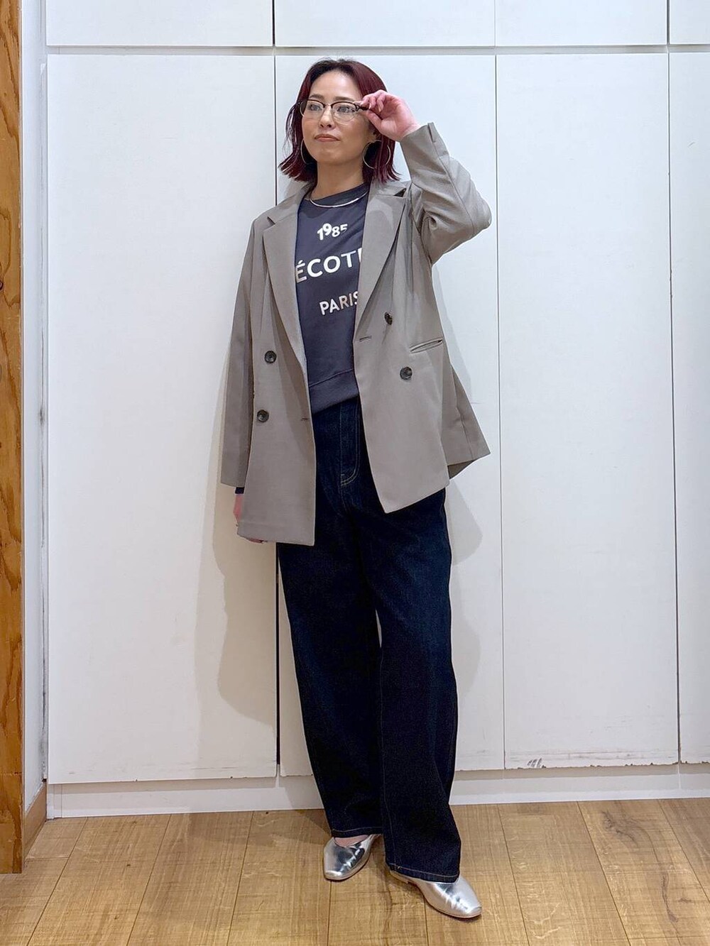 ブルー系のデニムパンツ、シルバー系のパンプス、ベージュ系のテーラードジャケットを着用したレディースの春コーディネートの2枚目の写真