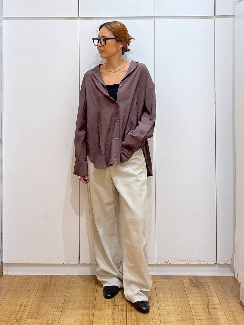 ブラック系のローファー、ブラック系のキャミソール、ベージュ系のデニムパンツを着用したレディースの秋コーディネートの3枚目の写真