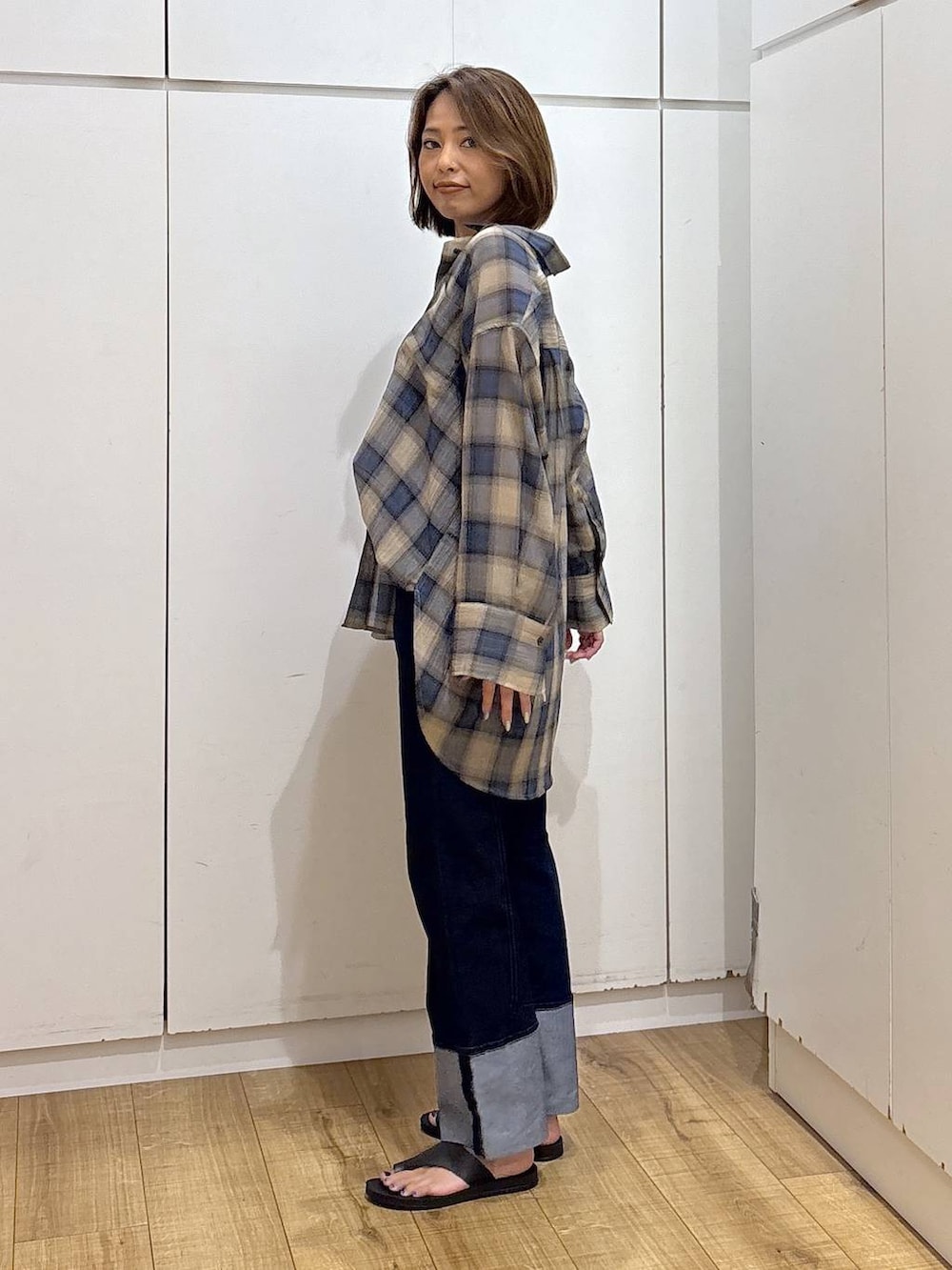 ブルー系のデニムパンツ、ブラック系のキャミソール、ベージュ系のシャツ/ブラウスを着用したレディースの夏コーディネートの5枚目の写真