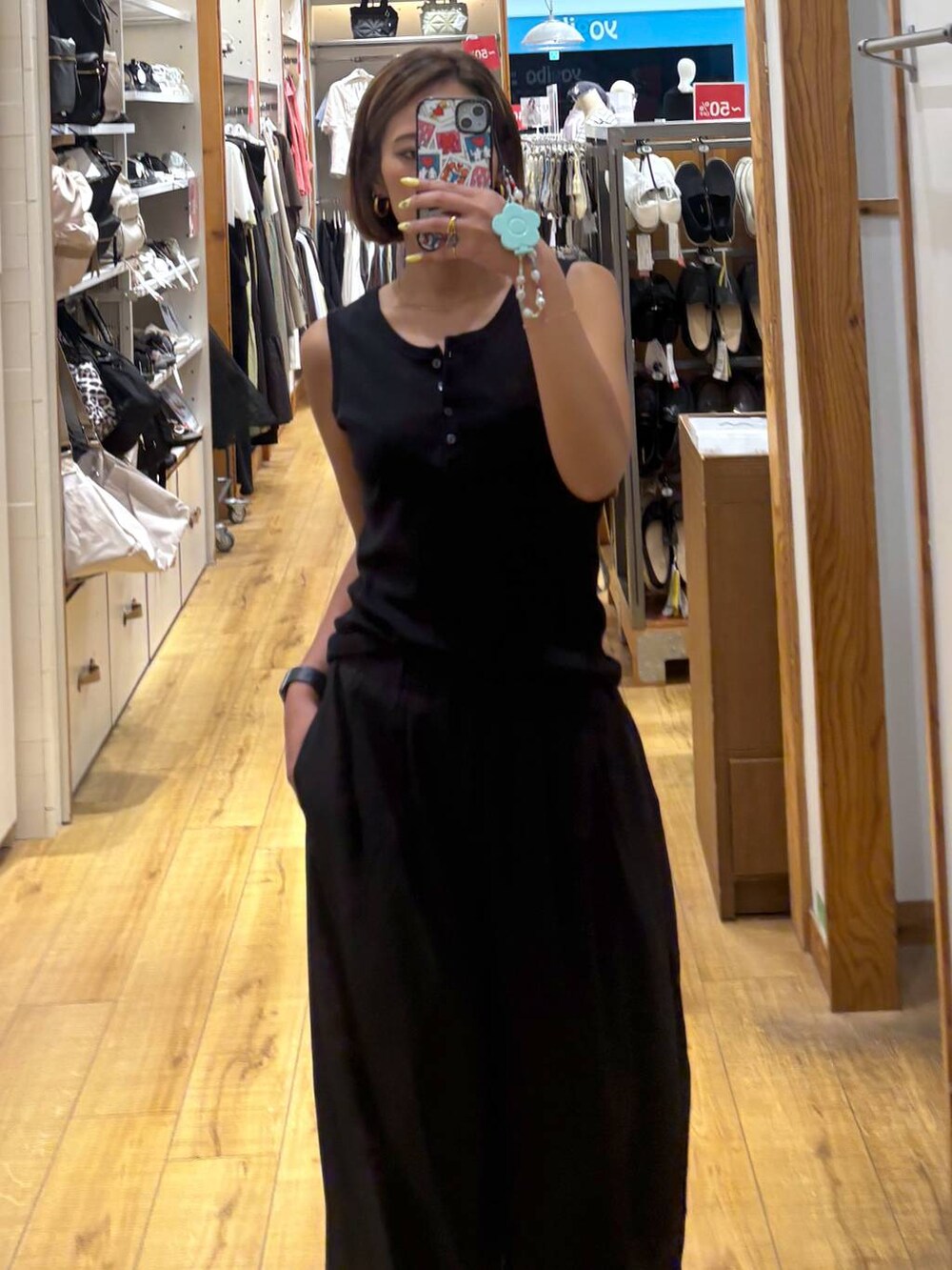 グレー系のその他パンツ、ブラック系のタンクトップ、ホワイト系のサンダルを着用したレディースの夏コーディネートの5枚目の写真